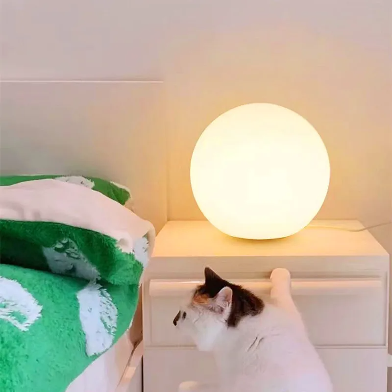 Transforme seu espaço com a elegante Luminária de Mesa em formato de bola, emitindo uma luz ambiente quente que cria uma atmosfera acolhedora e sofisticada. Ideal para decoração moderna e aconchegante.