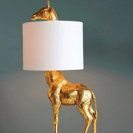 Luminária de mesa estilizada em forma de girafa, com acabamento em resina de alta qualidade, altura de 66cm. Design moderno e sofisticado, ideal para criar uma atmosfera acolhedora com sua luz suave e difusa. Perfeita para adicionar um toque elegante e contemporâneo ao seu espaço.